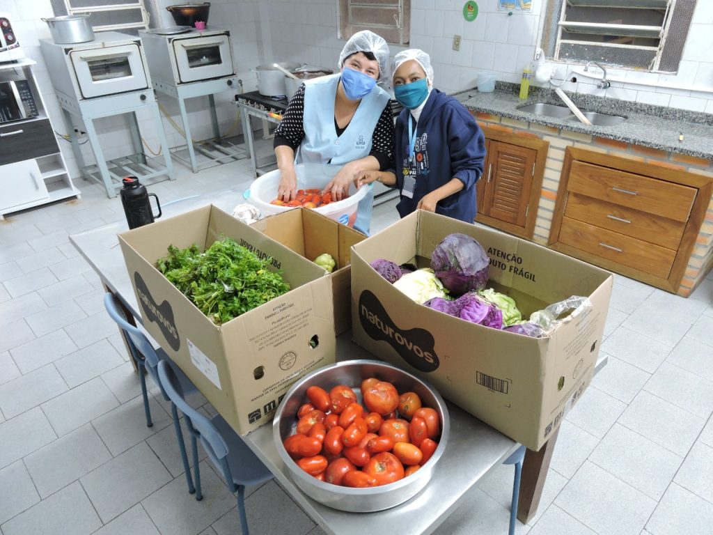 Colaboradores do Centro Social Marista Boa Esperança fazem marmitas para doação na comunidade